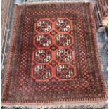 A hand-knotted Kayan rug, worked with a field of stylised guls to terracotta orange ground within