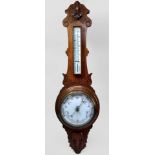 An oak-cased wall-hanging aneroid barometer with mercury thermometer, carved foliate decoration in