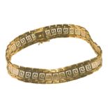 A 9ct yellow and white gold bracelet, in a greek-key design, with safety catch, weighs 13.6 grams.