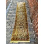 A hand-knotted Persian silk runner, worked with flora and fauna, in gold, brown and beige, with