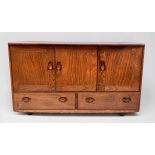 A blonde elm and beech Ercol sideboard, model 366, with three cupboard doors, above two drawers,