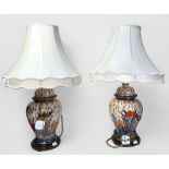 A pair of crackle-glaze pottery table lamps decorated with Imari palette and cream shades,
