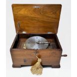 An Edwardian Polyphon, with side winding handle, with 17x metal music discs, in walnut case with