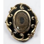 A Victorian pinchbeck and black enamel mourning pendant/brooch, lacking pin, of shaped oval form