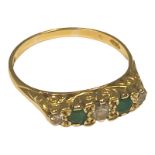 An 18ct yellow gold half hoop eternity ring, with three round diamonds, and two round emeralds, in a