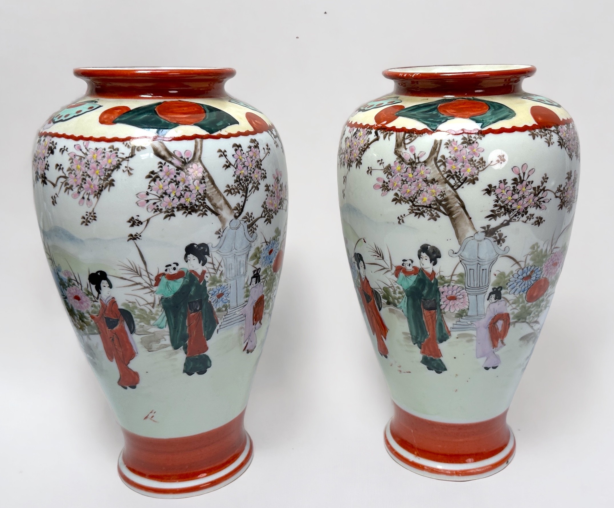 A pair of Japanese porcelain vases, of ovoid form painted with Geisha girls in a blossom landscape