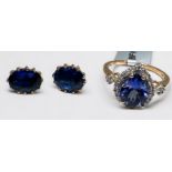 A 10ct yellow gold ring, set with a pear shaped tanzanite, halo set with small white stones,