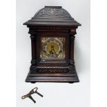 A German stained oak cased bracket clock, the brass dial with silvered chapter ring, Arabic numerals