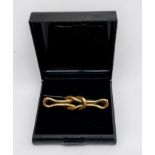 A 15ct yellow gold square-knot design brooch, with metal pin, weighs 3.9 grams.