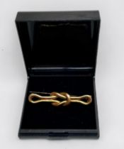 A 15ct yellow gold square-knot design brooch, with metal pin, weighs 3.9 grams.