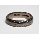 An 18ct white gold patterned wedding ring, 4mm, weighs 3.6 grams.