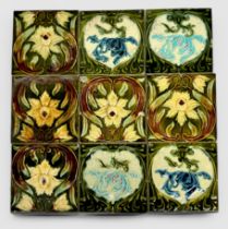 A set of nine glazed pottery fireplace surround tiles, with Art Nouveau floral decoration, some