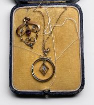 An Edwardian 9ct yellow gold garnet and seed-pearl scrollwork pendant, together with a 9ct yellow