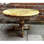 A circular onyx and brass coffee table, with pierced, foliate frieze, raised on baluster brass