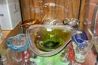 A quantity free-form coloured glass including bowls and vases (on two shelves)