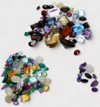 A quantity of assorted loose gemstones including amethyst, emerald, smoky quartz, aquamarine, opals,