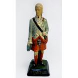 A vintage painted papier-mache advertising figure modelled as Prince Charlie, raised on black