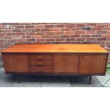 A 1960s teak sideboard by William Lawrence of Nottingham, with three cupboards and bank of drawers