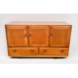 A blonde elm and beech Ercol sideboard, model 366, with three cupboard doors, above two drawers,