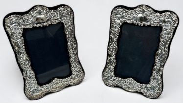 A pair of silver fronted easel picture frames, with floral and scrolled decoration, hallmarked