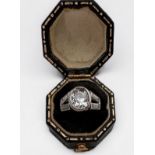 A platinum and diamond ring, rub-over set with an oval-shaped Victorian cut diamond to the centre,