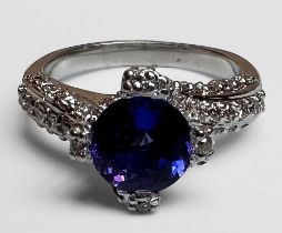 An 18ct white gold dress ring, set with a round faceted tanzanite to the centre, with 3 x rows of