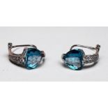 A pair of 14ct white gold earrings set with a large heart shaped faceted blue topaz to the centre,