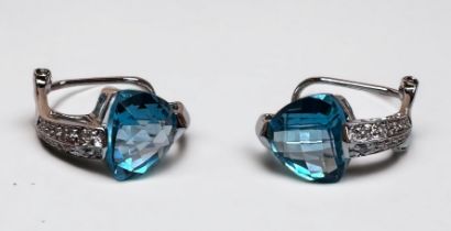 A pair of 14ct white gold earrings set with a large heart shaped faceted blue topaz to the centre,