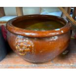 A large pottery jardiniere / planter, foo dog faces moulded in relief, lipped rim, brown gloss