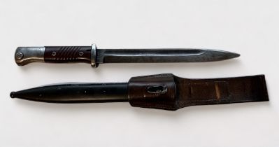 A German WWII Mauser K98 bayonet, with brown bakelite grips, metal scabbard dated 1939, with leather