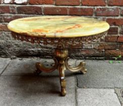 A circular onyx and brass coffee table, with pierced, foliate frieze, raised on baluster brass