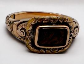 A yellow metal, tests as 14ct gold memorial ring, with chased floral engraving to the shoulders