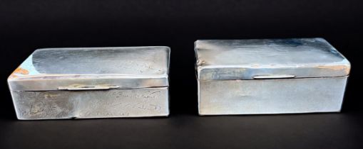 Two silver cigarette boxes, both presented to Lieutenant Commander E. F. Coggins, one to commemorate
