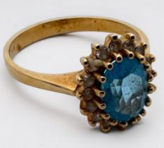 An 18ct yellow gold cluster dress ring, set with an oval-shaped blue topaz to the centre, surrounded