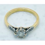 An 18ct yellow gold and platinum ring, claw set with a round brilliant cut diamond to the centre,