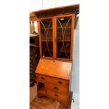 A Liberty 'style' oak bureau bookcase, the top with adjustable shelves enclosing by glazed doors,