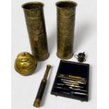 A pair of WWI brass shell cases, with Oriental decoration to sides, a brass inkwell modelled as a