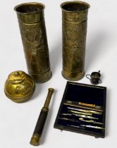 A pair of WWI brass shell cases, with Oriental decoration to sides, a brass inkwell modelled as a