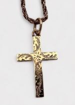 A 9ct yellow gold solid cross with foliate engraving to the front, on 9ct yellow gold double-twist