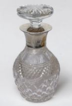 A cut glass decanter of globular form with flared, silver-mounted rim and stopper, silver mount by