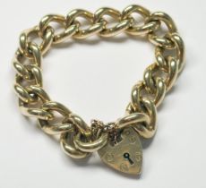 A 9ct yellow solid gold curb link bracelet with heart- shaped padlock and safety chain, hallmarked