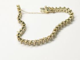 A 14ct yellow gold tennis bracelet, with gold safety chain, claw set with 38 x round brilliant cut