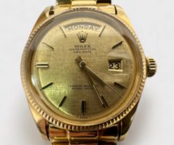 A gents 18ct gold, 36mm Rolex Day-Date wristwatch, the champagne linen dial with gold batons