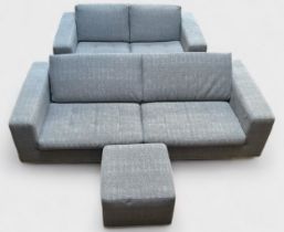 A Natuzzi three-seater sofa, mathing two-seater sofa and footstool, of low low back design with