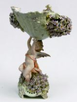 A Sitzendorf porcelain centrepiece, modelled as a female cherub supporting a flower encrusted shell,