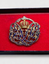 An enamelled gilt-metal Horse Racing badge of Queen Victoria’s monogram with crown, date-1890