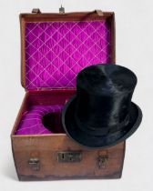 A vintage top hat with coat of arms to interior, housed in fitted and lined tan leather, lockable