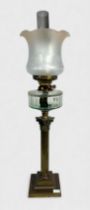 A Victorian oil lamp, brass base of classicl column on stepped square base, glass resevoir and