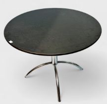 A 20th century circular dining table with black granite top and chromium plated tubular steel