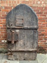 An extremely heavy Medieval Oak lancet-shape castle door, of plank and ledge construction with
